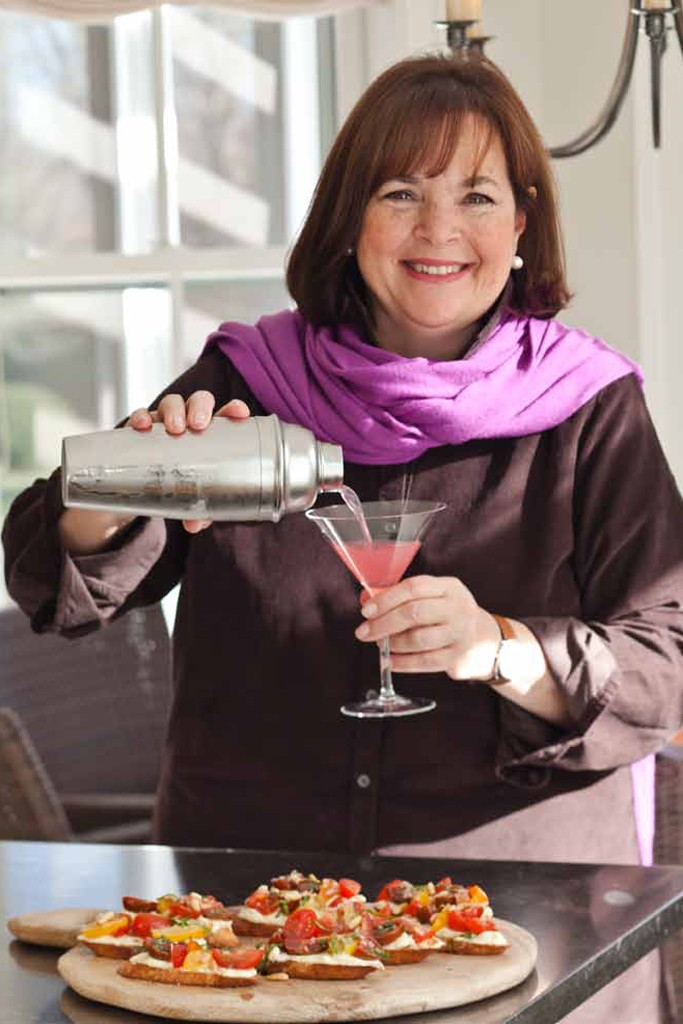 Ina Garten holding a cocktail shaker and a cocktail.